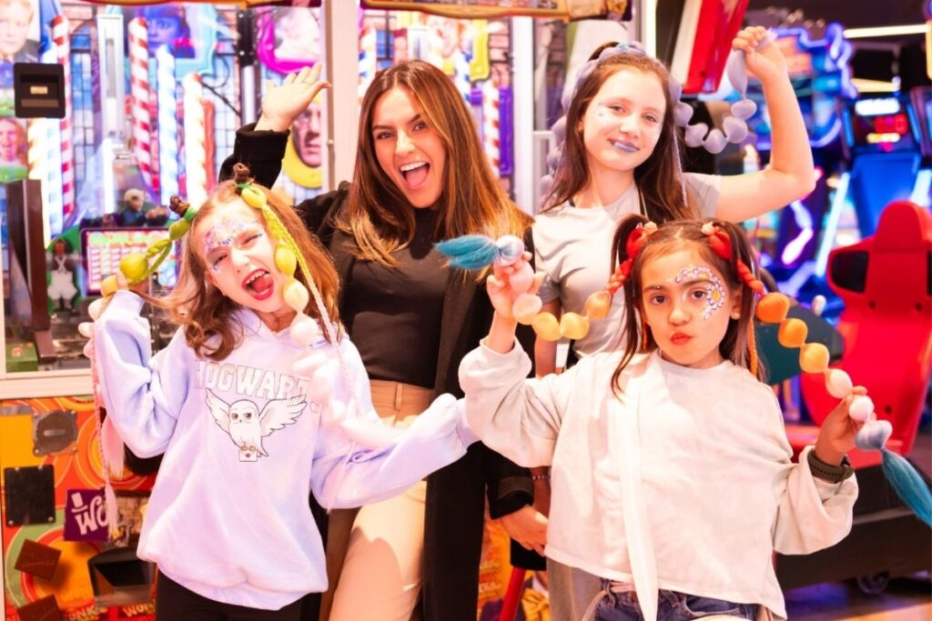 Kids party entertainment in Sydney: how parents choose the right experience 2 Group of girls with glitter face designs and bubble braids at the Kids Ultimate Girls Party in Sydney.